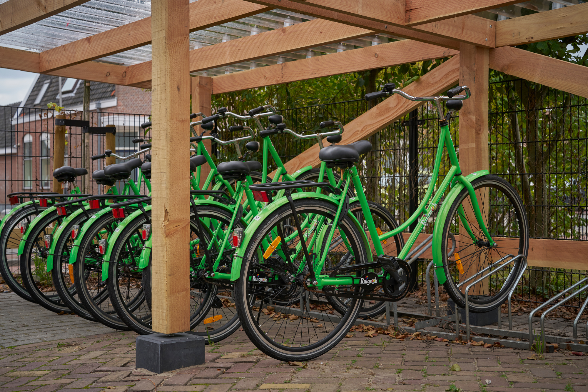 Groene fietsen met Ruigrok-logo in rek, symbool voor duurzame mobiliteit binnen Ruigrok Groep